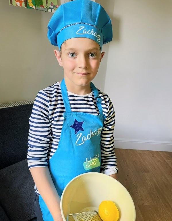 Zachary in his chef's hat and apron, grating lemon into the mixing bowl — the 2-Ingredients Chef project